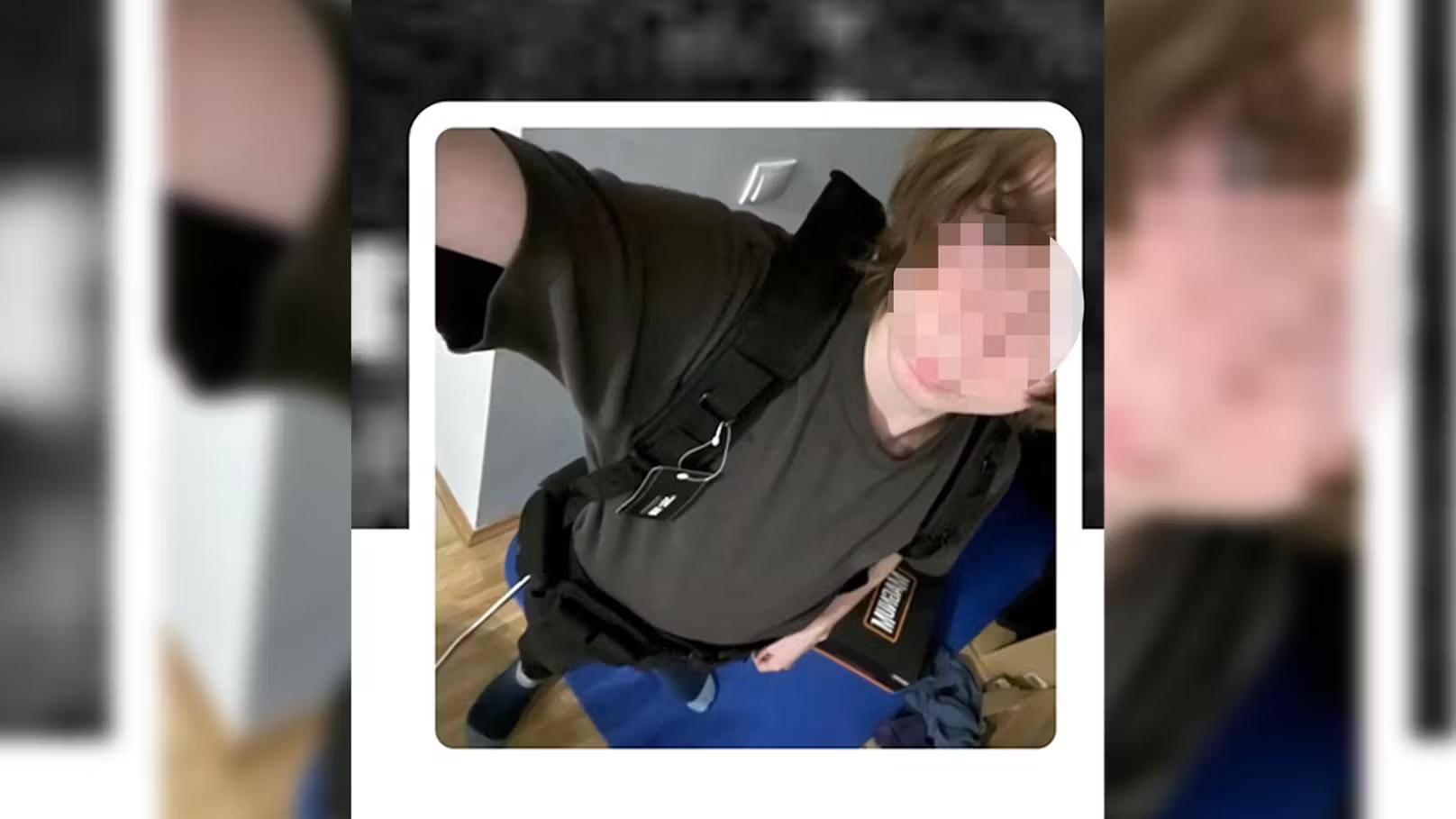 صورة ذاتية لشاب يرتدي ملابس داكنة ويحمل حقيبة متعلقة على كتفه داخل غرفة. تظهر خلفية الغرفة بشكل غير واضح.