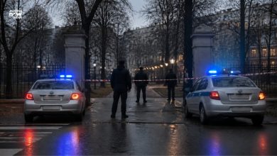 سيارات شرطة بأضواء زرقاء عند مدخل حديقة مطوّقة مساءً
